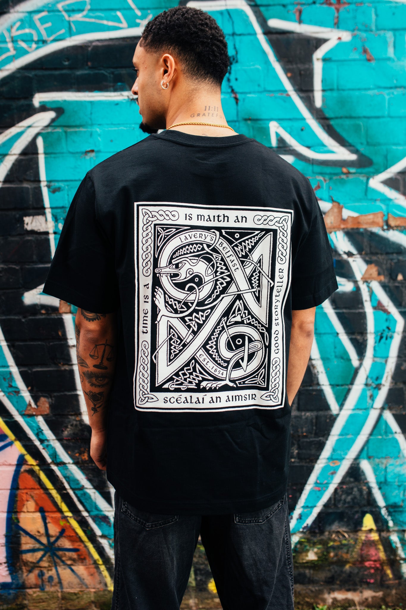 An Scéalaí white on black t-shirt back design